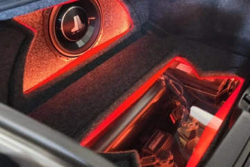 Custom-built car audio and lighting system with JL Audio subwoofer and red LED highlights, professionally installed by SounDelux in San Diego.
