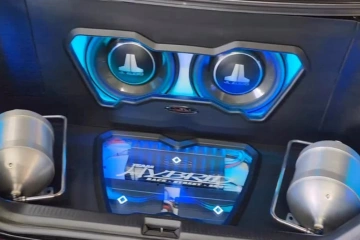 High-end custom car audio installation by SounDelux in San Diego featuring JL Audio subwoofers and illuminated blue LED accents.